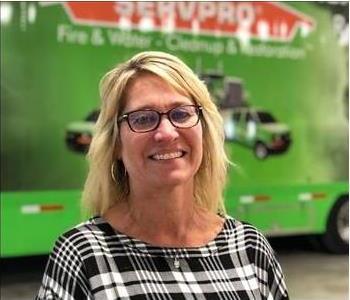 woman standing in front of a green SERVPRO trailer in the background