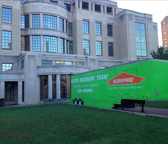 A SERVPRO semi tactor trailer staged in front of a municipal building