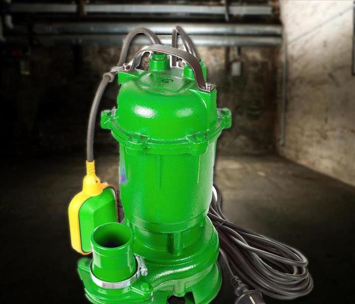 a green colored sump pump in a basement